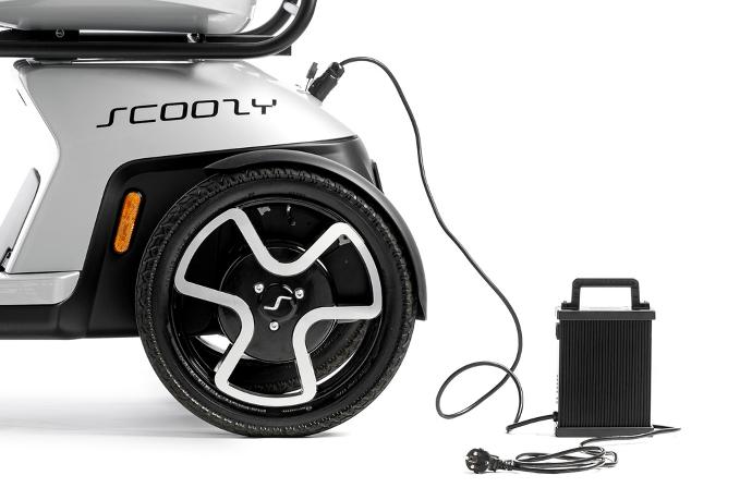 Lader in scootmobiel Scoozy gestoken. Scootmobiel opladen