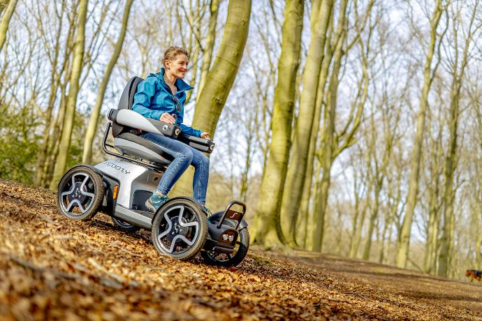 Off road scootmobiel Scoozy met 4 grote wielen in het bos.